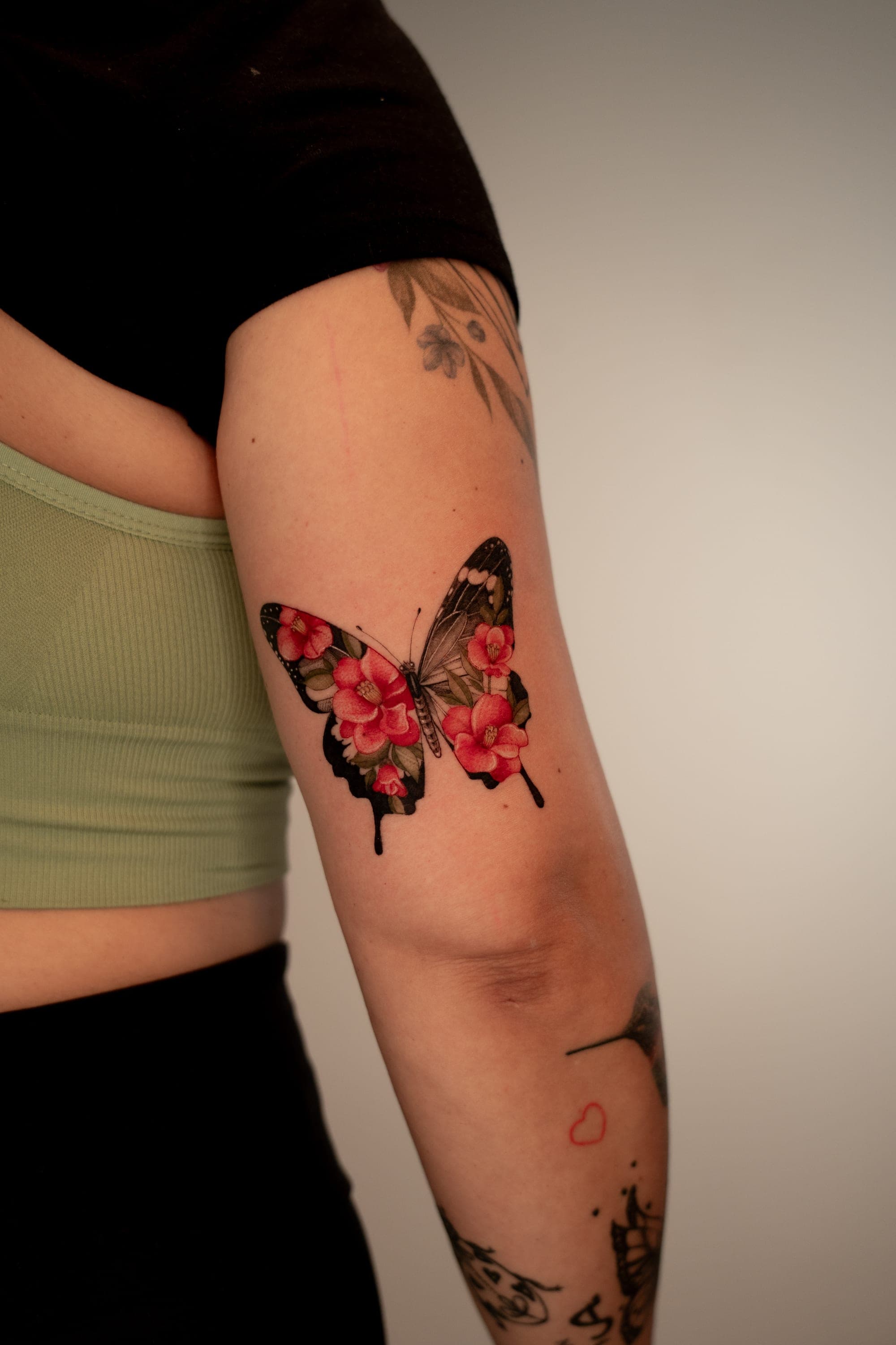 Butterfly filled with red flowers tattoo