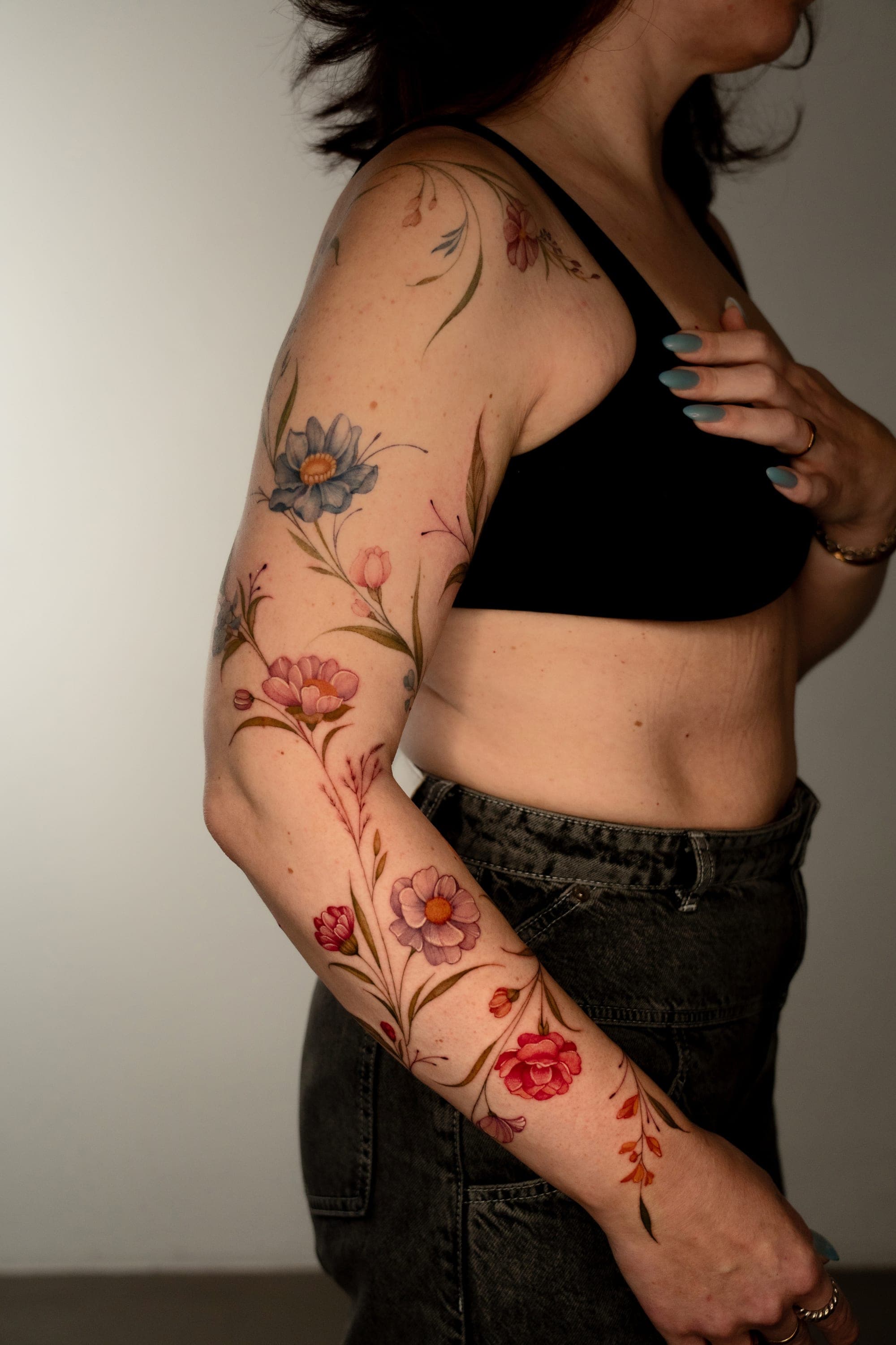 Blue and pink botanical flower sleeve tattoo