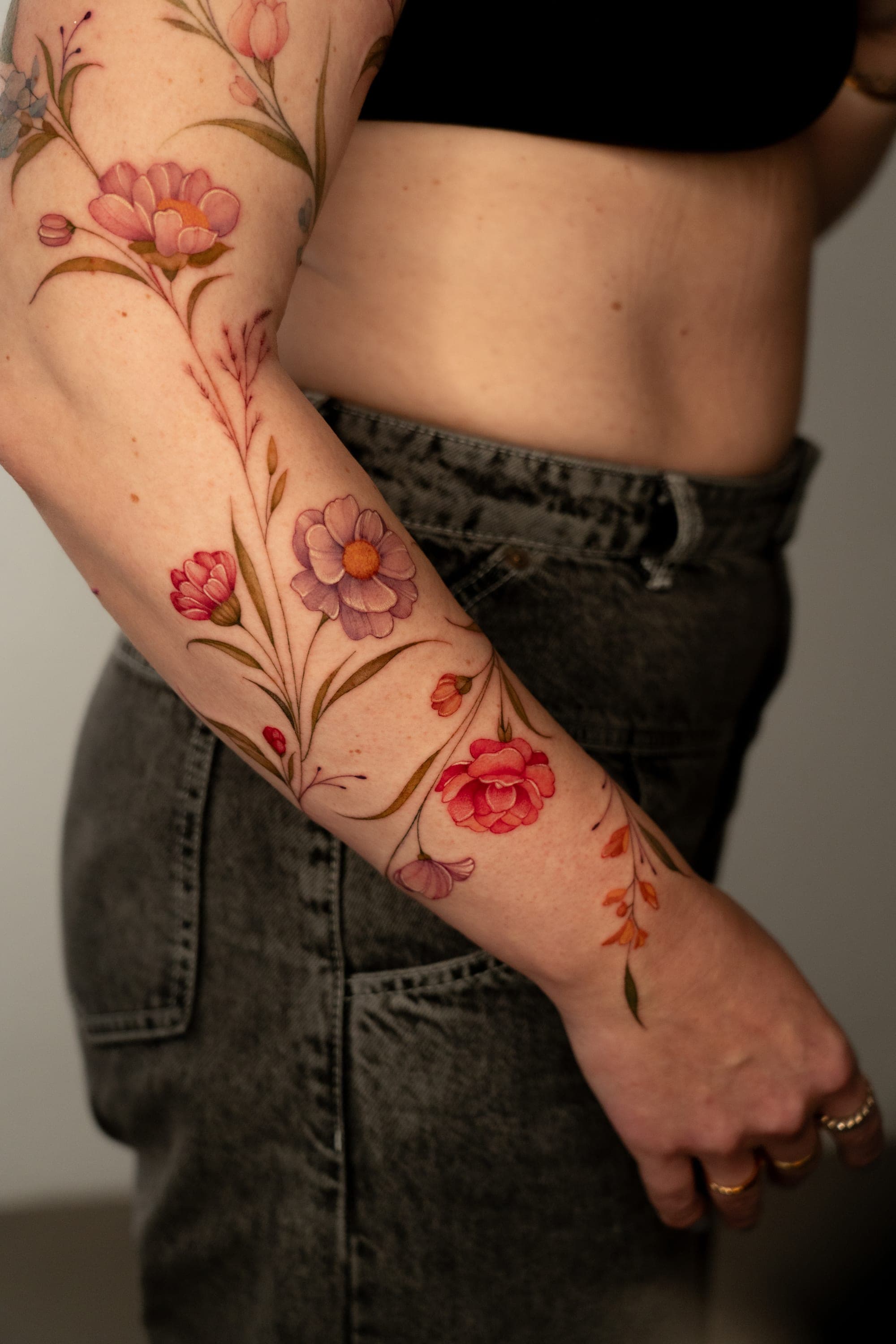 Colorful flower sleeve tattoo detail on forearm