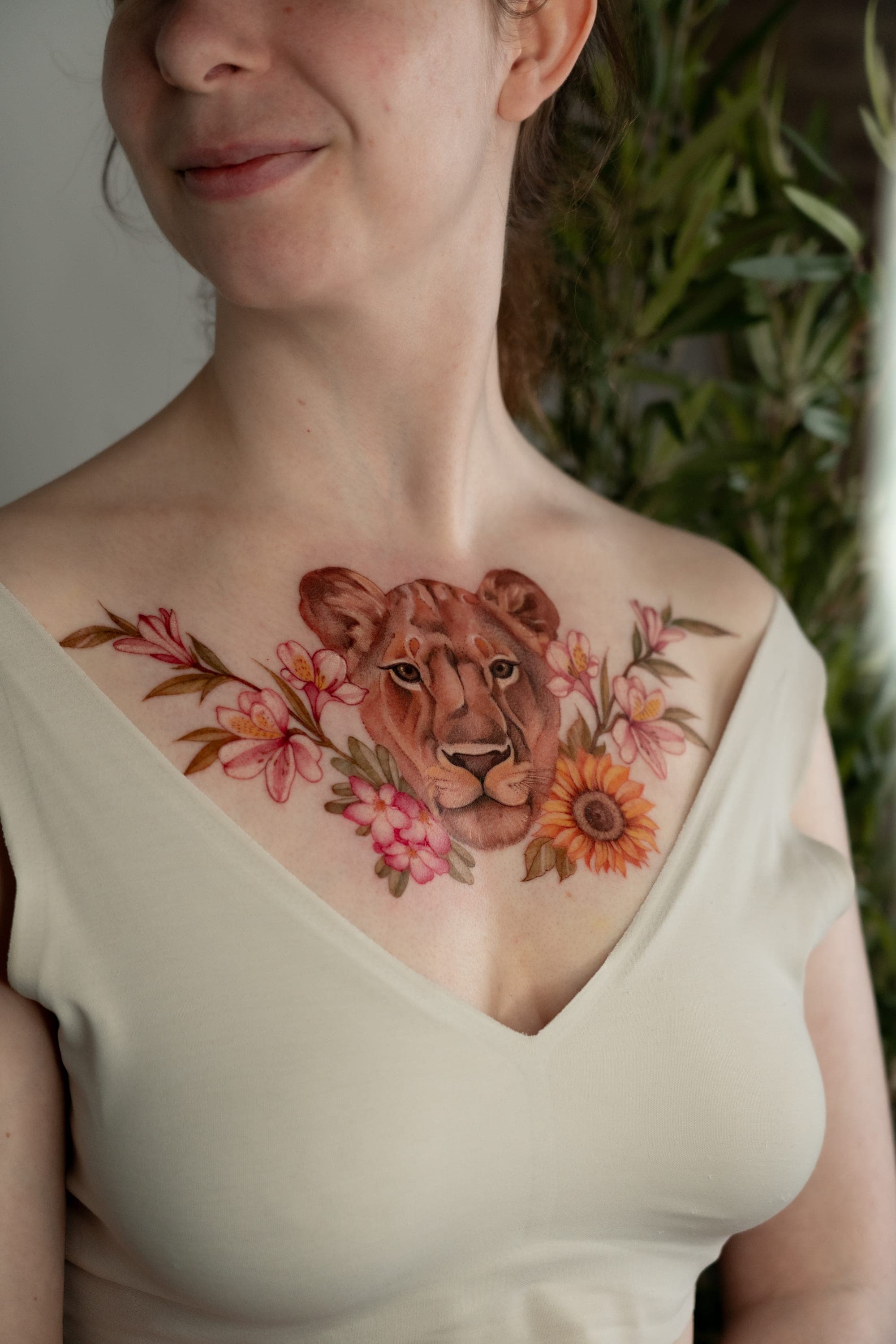Lion portrait with colorful flowers chest tattoo