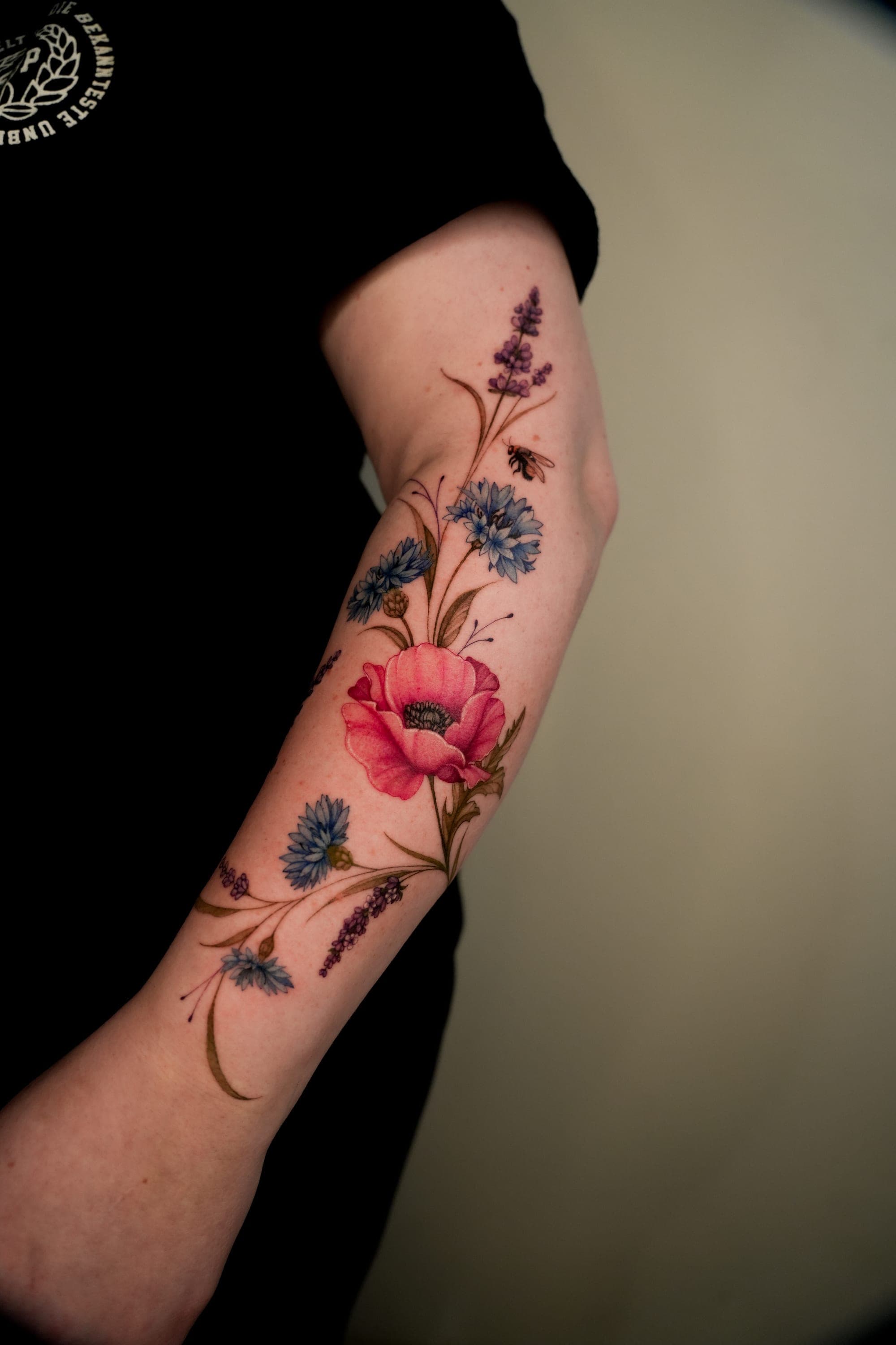 Cornflower and lavender forearm tattoo with bee