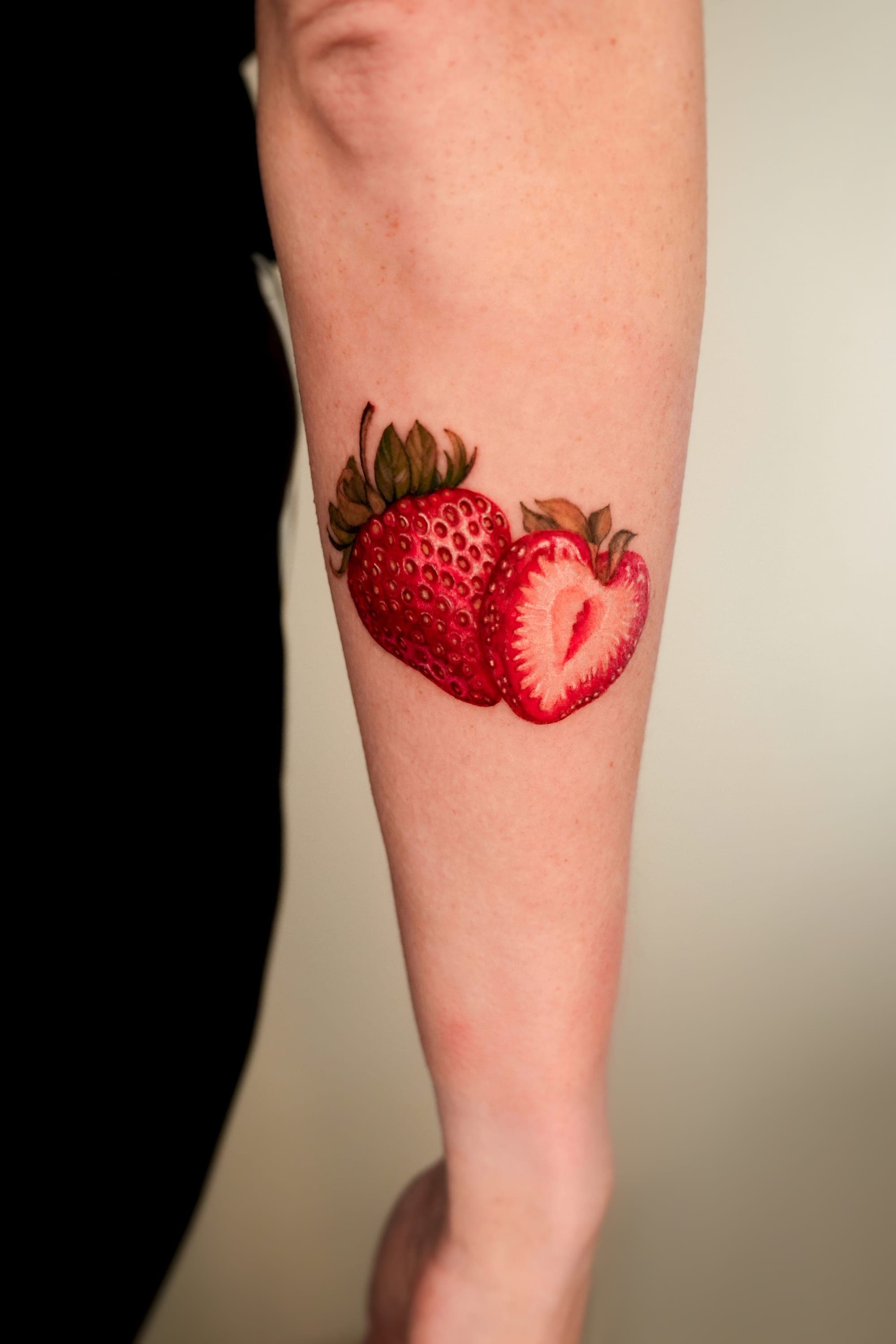 Realistic strawberry tattoo on leg